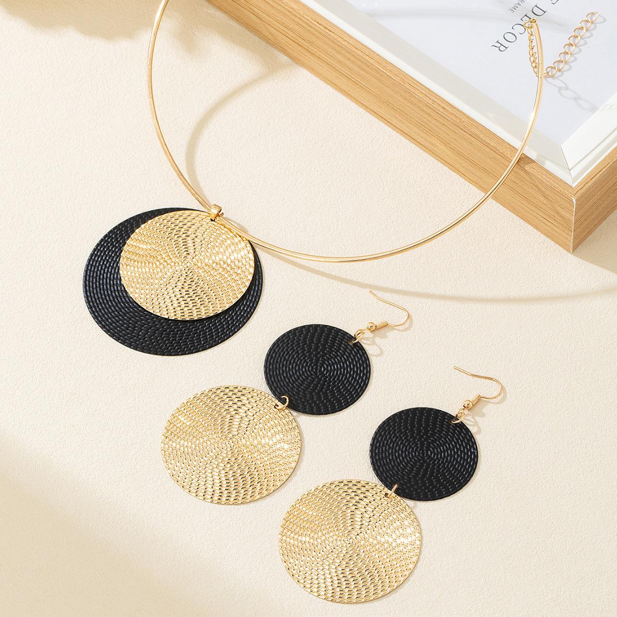 

Преувеличенный стиль: Комплект крупных круглых серег с кованой текстурой и чокера с горошком - Элегантная мода высокого класса.