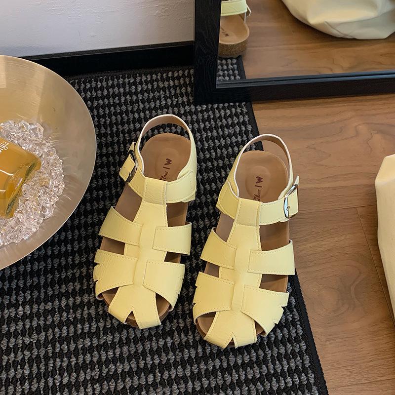 Gewebter Feenwind hohler Beutel Kopf Rock Sandalen Damen Sommer mit 2025 neuen flachbodigen vielseitigen lässigen Schweinekäfigschuhen