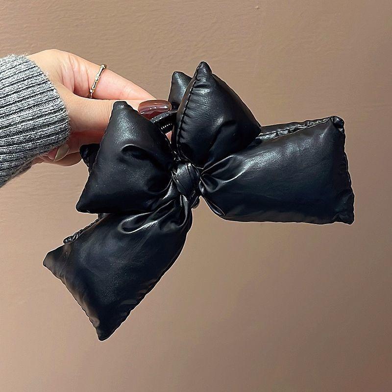 

A girl with a large black bow clip, a thick hair clip with a big chin, and a fashionable anti-slip winter hair accessory