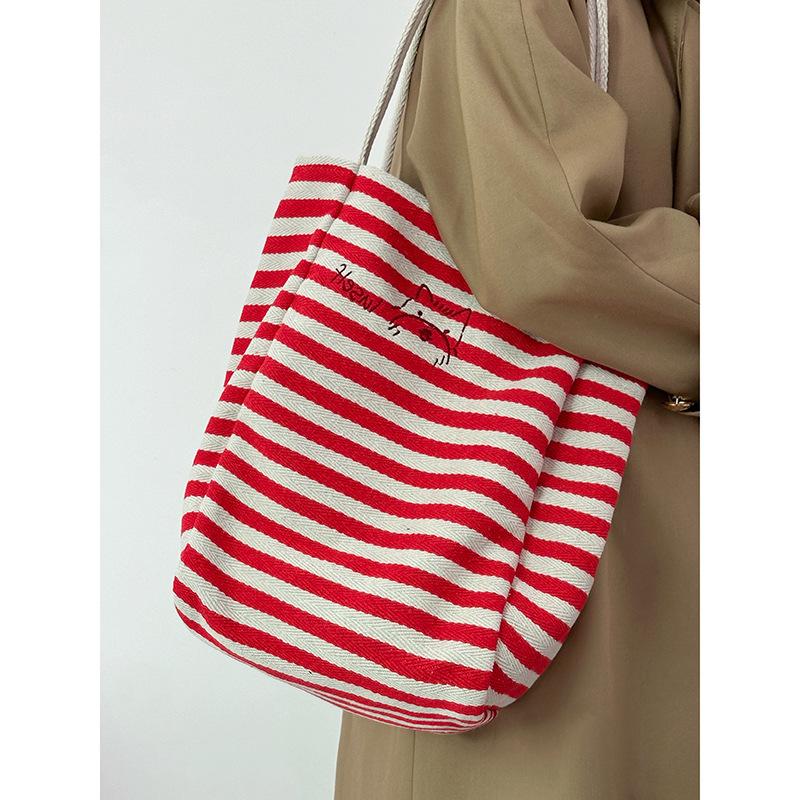 Large capacity striped canvas bag women's 2025 new niche embroidery lazy wind commuter portable shoulder tote bag