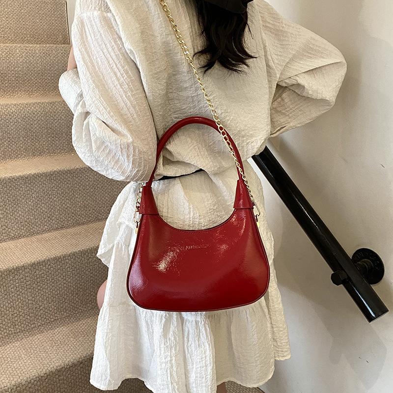 Fashion birth girl small bag 2025 new patent leather design sense portable crescent bag hand carry niche unique underarm bag