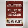 Vintage Rusty Metal Sign 'THIS YEAR THOUK THOUSANDS OF MEN WILL DIE - NO WE WON'T' Distressed Dripping Text Red White Background