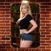 Hochauflösende Blechmalerei Blondine im schwarzen Crop-Top und Jeans-Shorts mit Bücherregal-Hintergrund Vintage-Metallschild Wand A