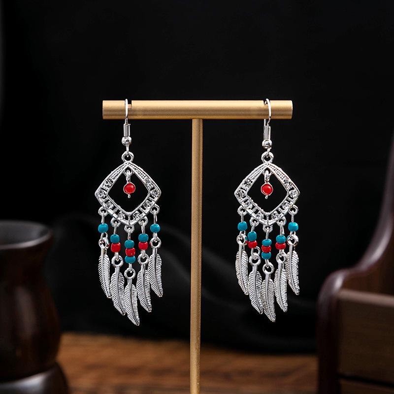 Boucles d'oreilles pendantes à pompons de plumes ethniques - Style argent Miao imitation, article touristique populaire, design mignon de haricot.