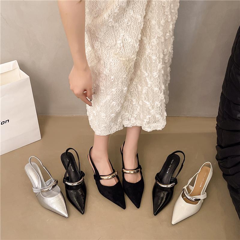 A Woman Wearing Half-slippers with An Inwardly Raised Metal Buckle Toe Cap and A Genuine Leather Pointed Toe on The Outside