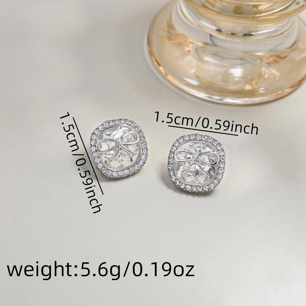 Eleganckie kolczyki w kształcie kwadratowej kokardki z cyrkoniami, prosty, ale delikatny design dla swobodnego szyku.