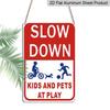2D Flat Slow Down At Play Metal Sign - Durable Metal Safety Signage, 12*8 Inches, Easy To Install, Red and White with Blue Graphics, Perfect for