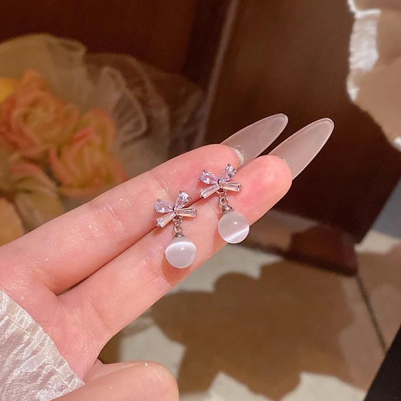 

Изысканные серьги-гвоздики в форме банта с цирконами для женщин, отличающиеся легкой роскошью и нишевым дизайном, с подвеской в форме кошачьего глаза на висячей цепочке.