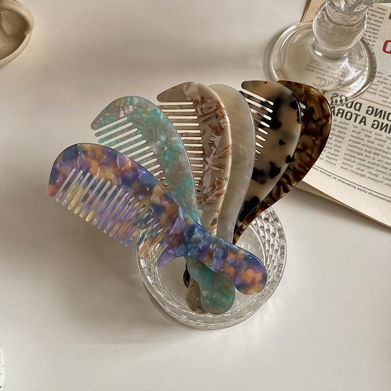 Elegant and compact tortoise shell acetate hair comb for easy portability.