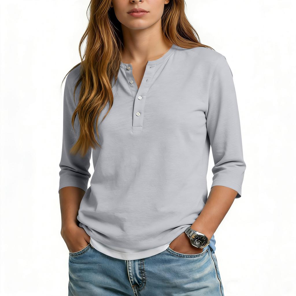 Camiseta informal de mujer con cuello en V, manga tres cuartos y botones decorativos.