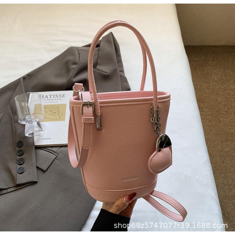 New niche simple solid color lychee pattern texture hand carrying bucket bag versatile foreign style commuting messenger women's bag