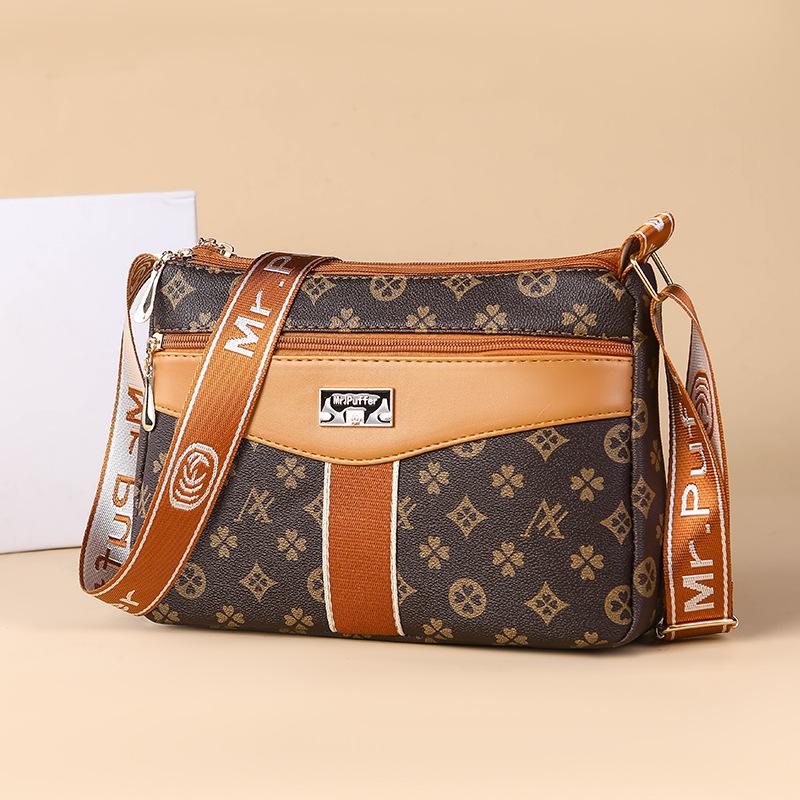 

Пожилая мать средних лет покупает многофункциональную сумку через плечо большой вместимости на весну