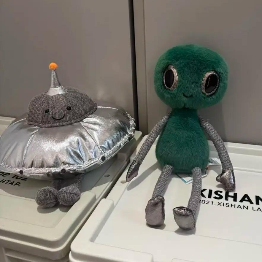 Peluche Espace Mignonne Alien Vert Souriant Soucoupe Volante Argentée Poupées Extraterrestres Douces Remplies Cadeau Adorable pour Fans de Science-Fiction Décoration de Maison