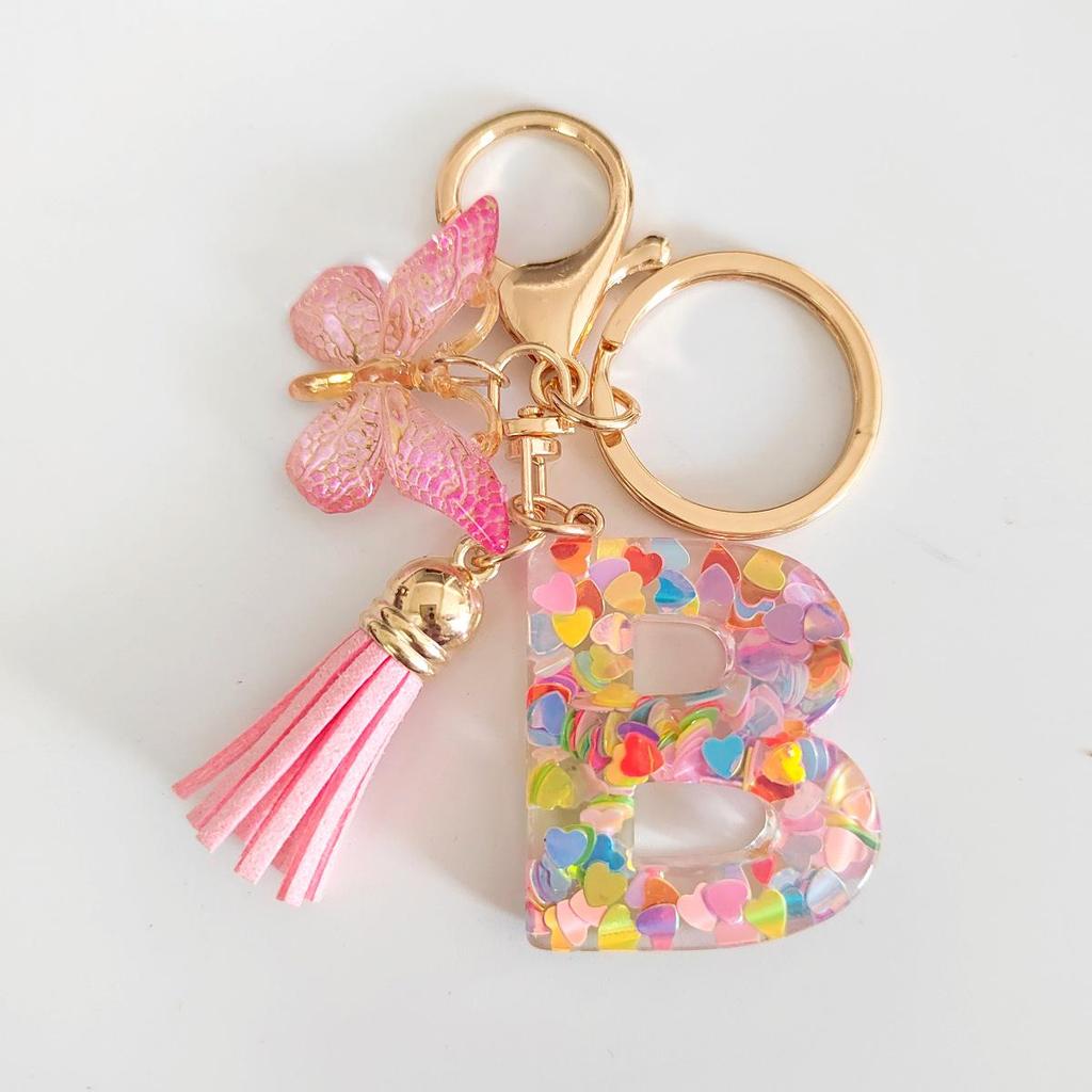 Rosa Glitzer Epoxidharz Schlüsselanhänger mit englischem Buchstaben und Schmetterlingsquaste