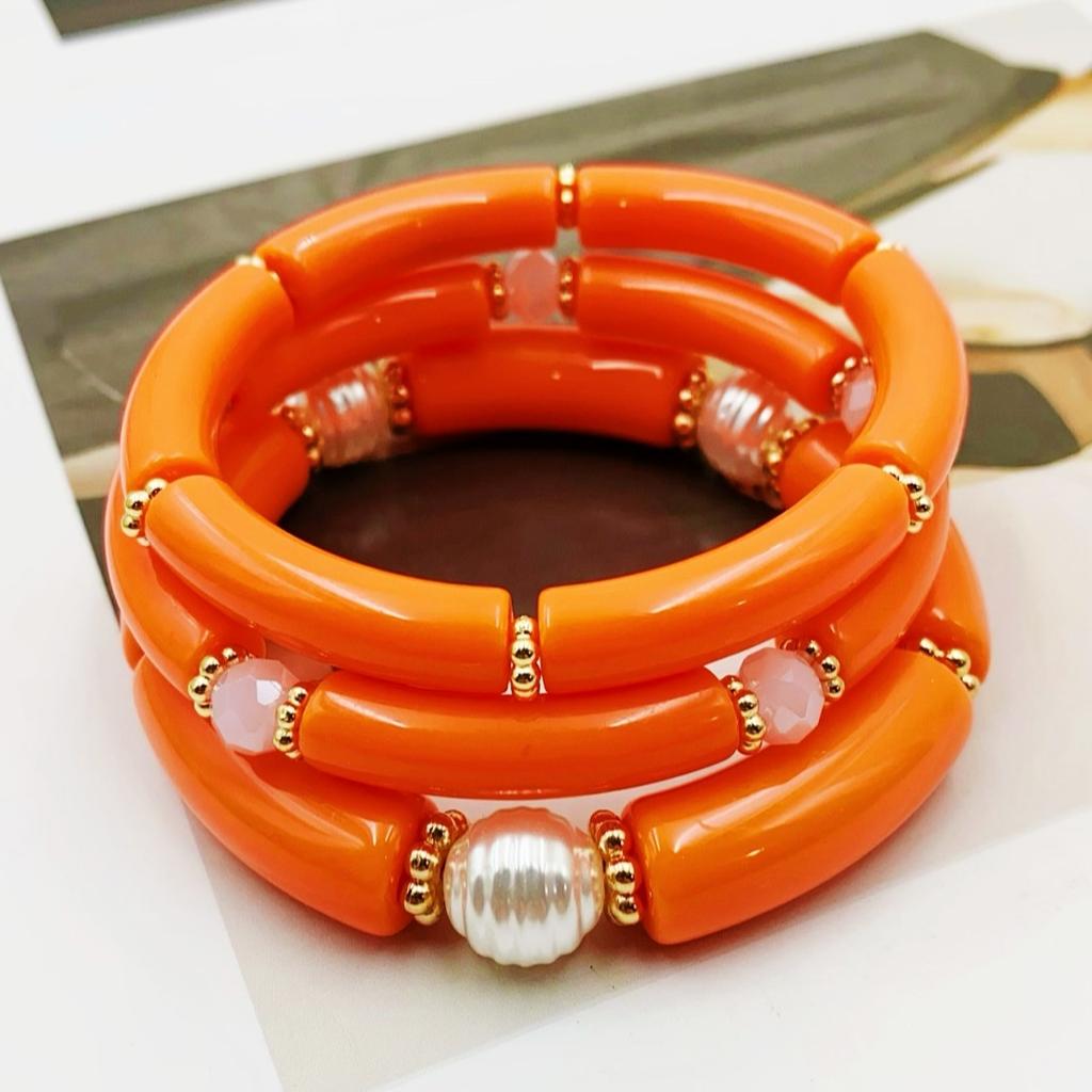 A set of three acrylic tubes connected by small golden flowers, adorned with crystal and faux pearl decorations, suitable for a lady's party.