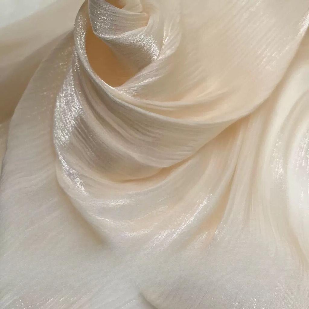 Soft shiny creased organza fabric with a smooth texture suitable for wedding dresses formal gowns and designer clothing fabrics