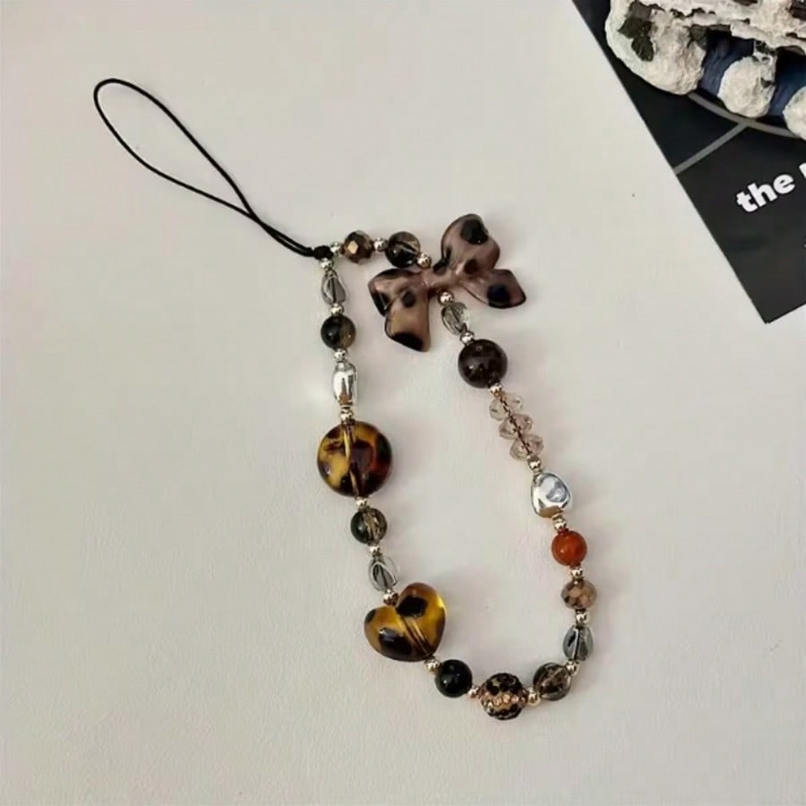

A fashionable mobile phone lanyard adorned with leopard print bow and bead decorations, used as an anti lost phone lanyard Polyester Fiber