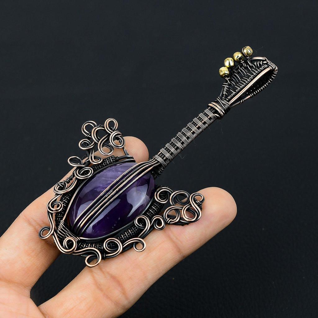 Gitarrenförmiger Amethyst-Edelstein mit Kupferdraht umwickelt, handgefertigter Schmuckanhänger als Geschenk