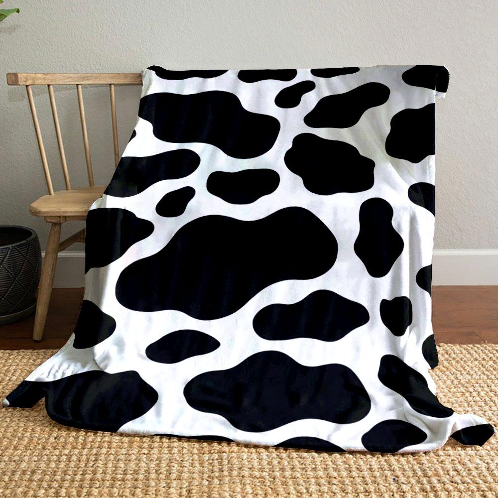 Black irregular spots on a white background resembling a cow print. for all seasons blanket lunch break throw gift