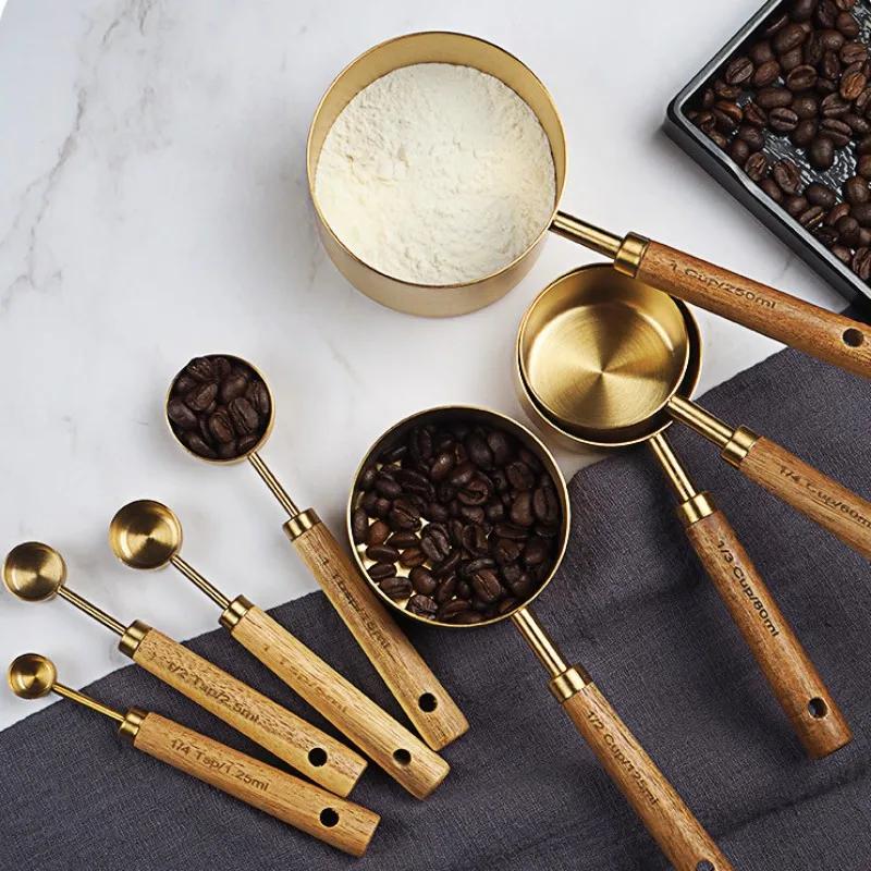 A Set of Eight Stainless Steel Measuring Cups and Wooden Handled Spoons for Kitchen Baking Tools, Measuring Tools, and Scales