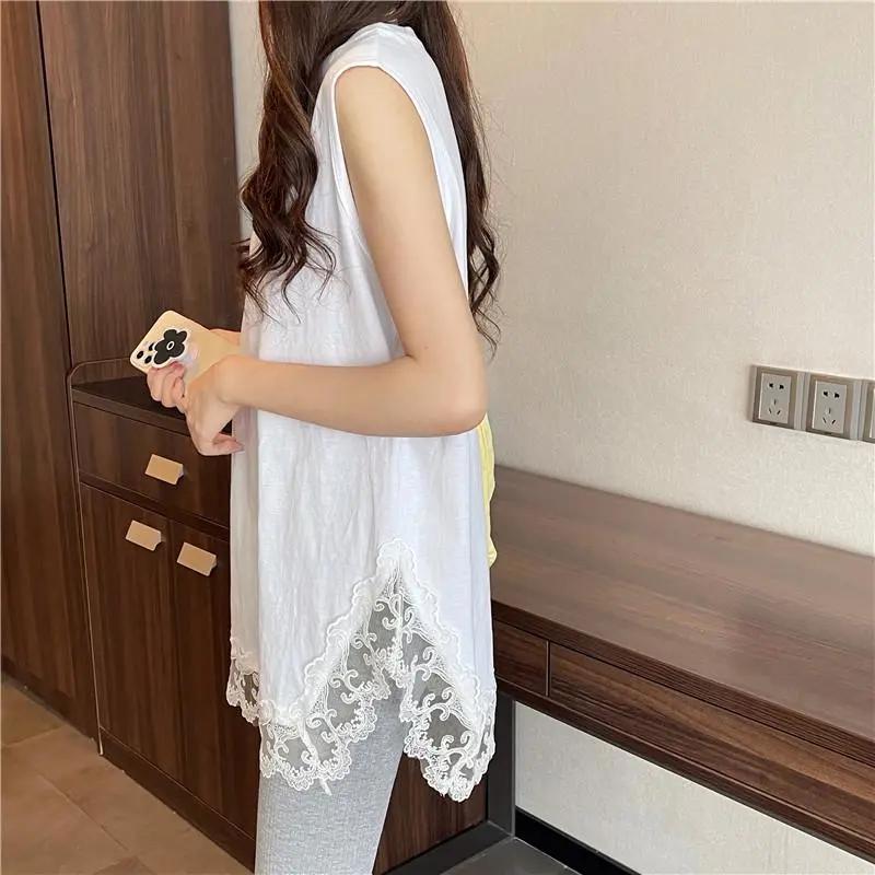 Stratificazione estiva da donna: Una T-shirt a maniche corte, di media lunghezza, dalla vestibilità ampia, con rifiniture in pizzo sull'orlo, indossata come strato base