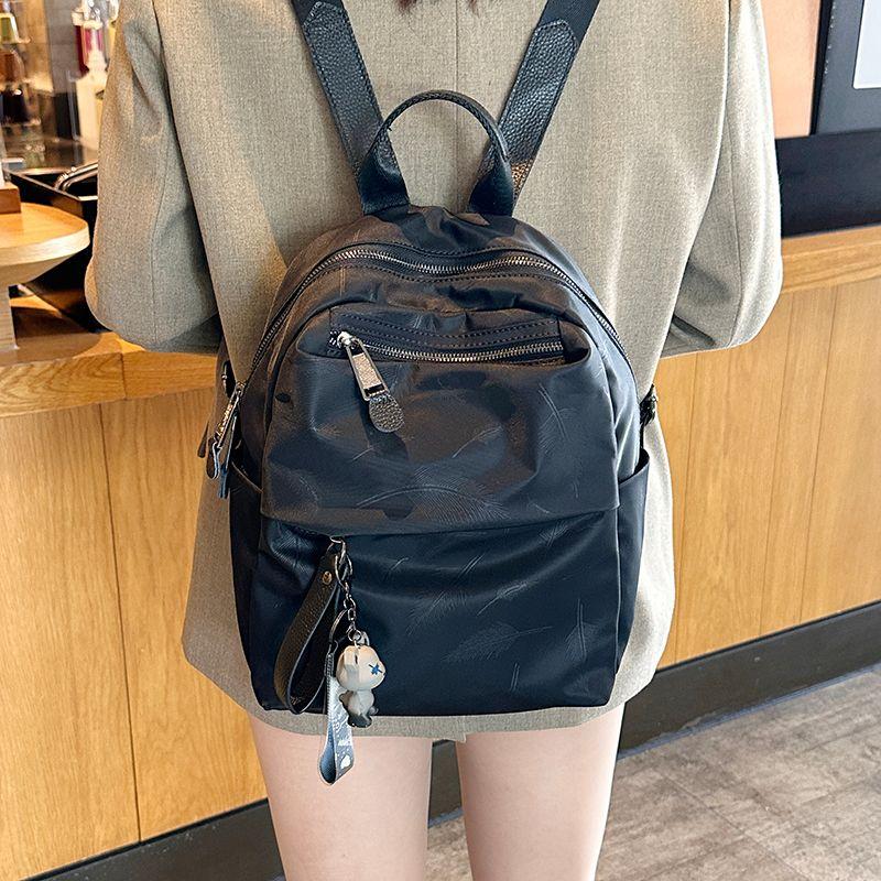 

Backpack Women s 2025 New Arrival Fashion Waterproof Oxford Cloth Backpack Student Schoolbag Computer Bag Large Capacity Travel Bag Small size feather belt Bear pendant