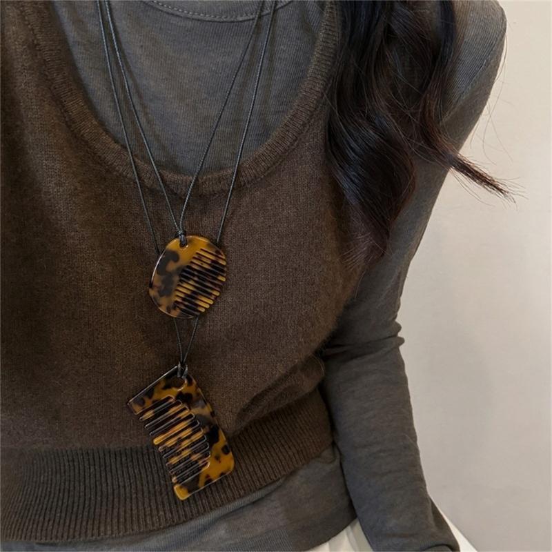 Modische Halskette mit Kammanhänger zum Stylen von Fransen. Tragbares, robustes Schmuckaccessoire aus Acryl für Damen und Herren im täglichen Gebrauch.