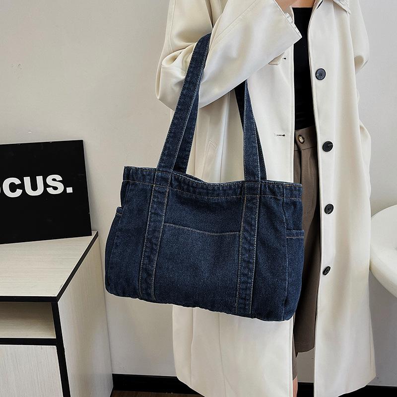 En denimväska med stor kapacitet En avslappnad och mångsidig toteväska för skola, pendling och en axelväska