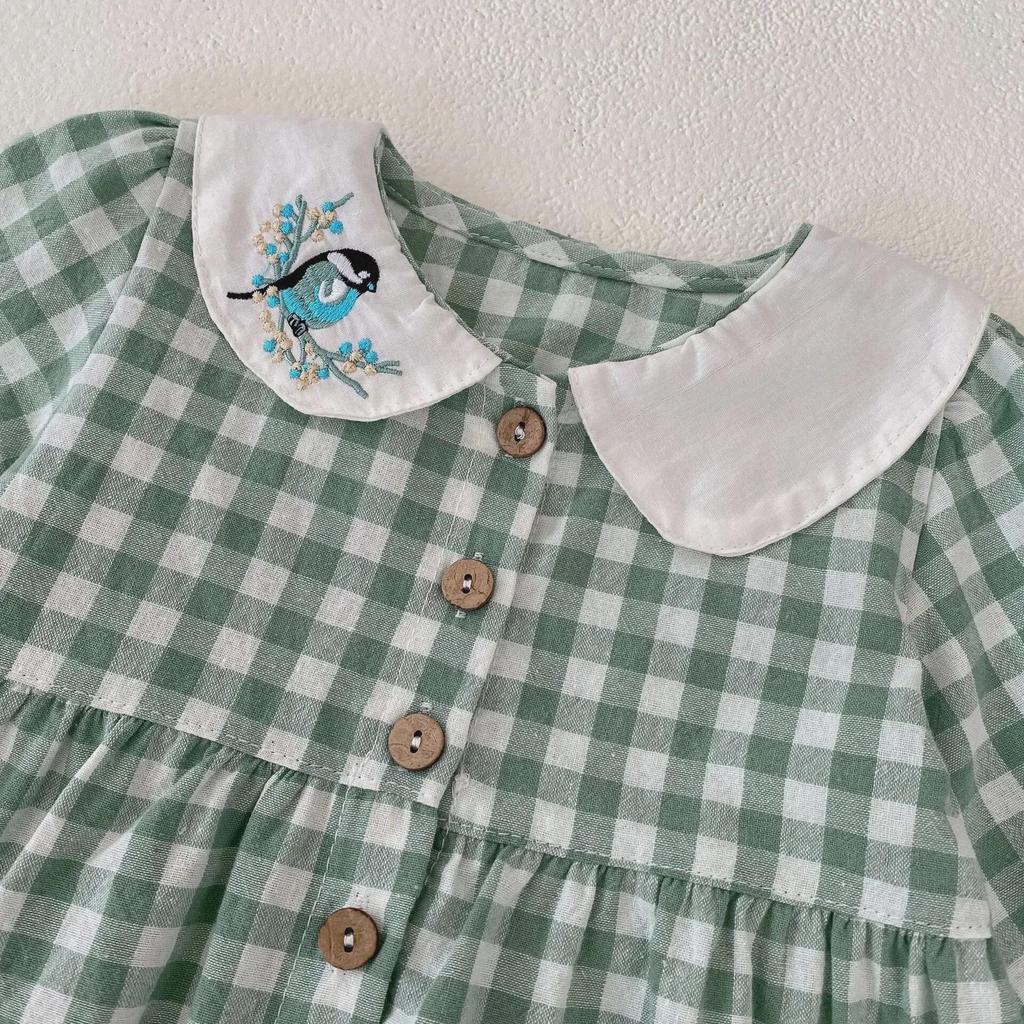 Abito a quadri da bambina autunno 2025 con ricamo di gazza e colletto da bambola.