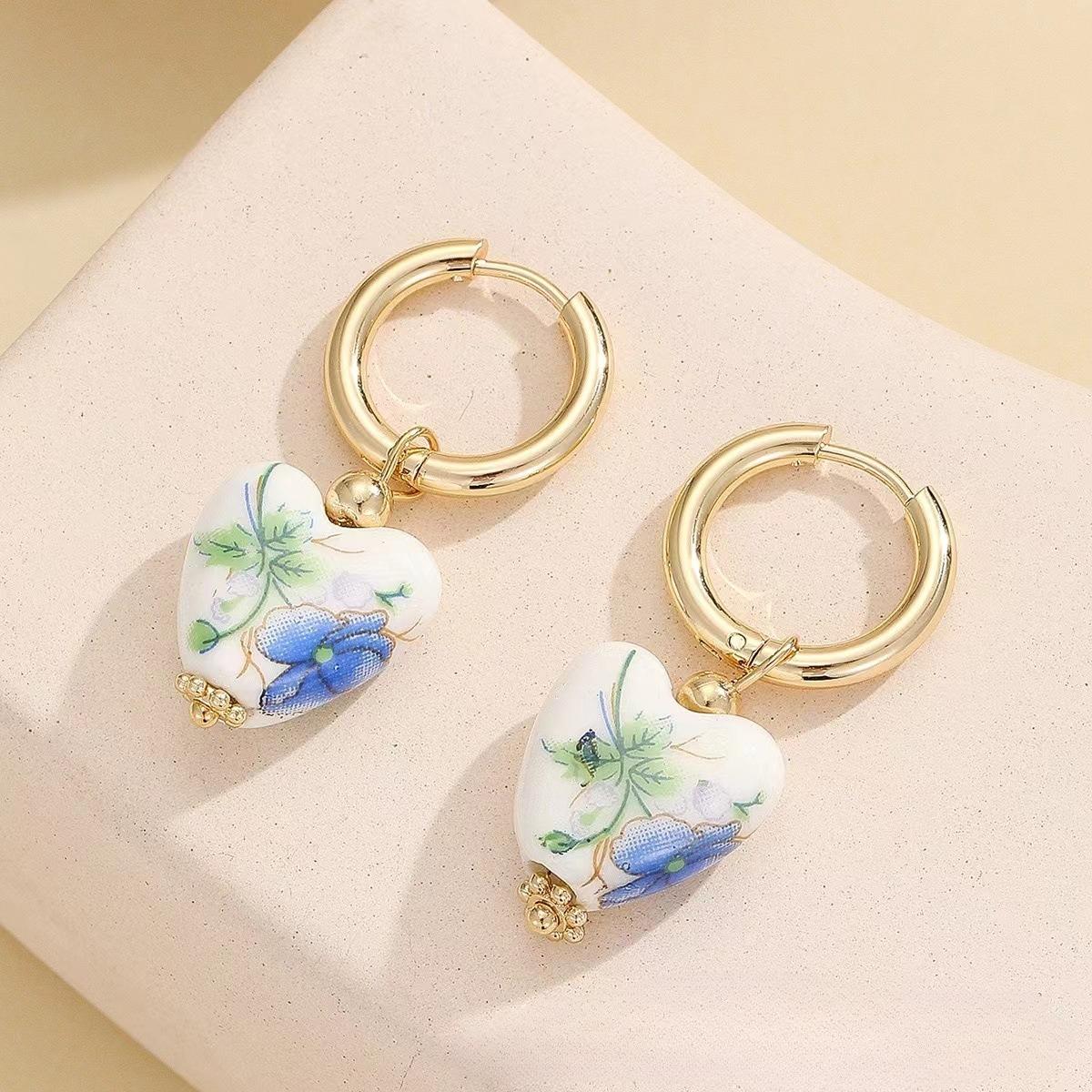 

Пара винтажных серег в китайском стиле в форме синих керамических сердец, подходящих для повседневной носки.