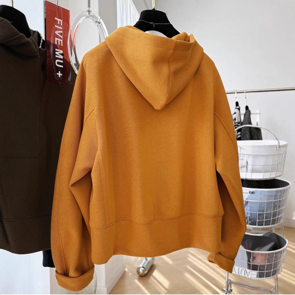 En lös, avslappnad och tillbakalutad huvförsedd tröja med halv dragkedja för kvinnor under hösten, som är extremt vacker