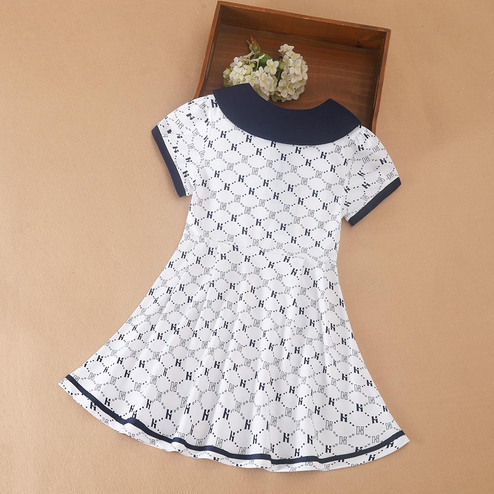 Flickornas tryckta pikétröja klänning med marinblå krage Kortärmad A-linjeformad klänning med monogrammönster Barnvita sommarklänningar