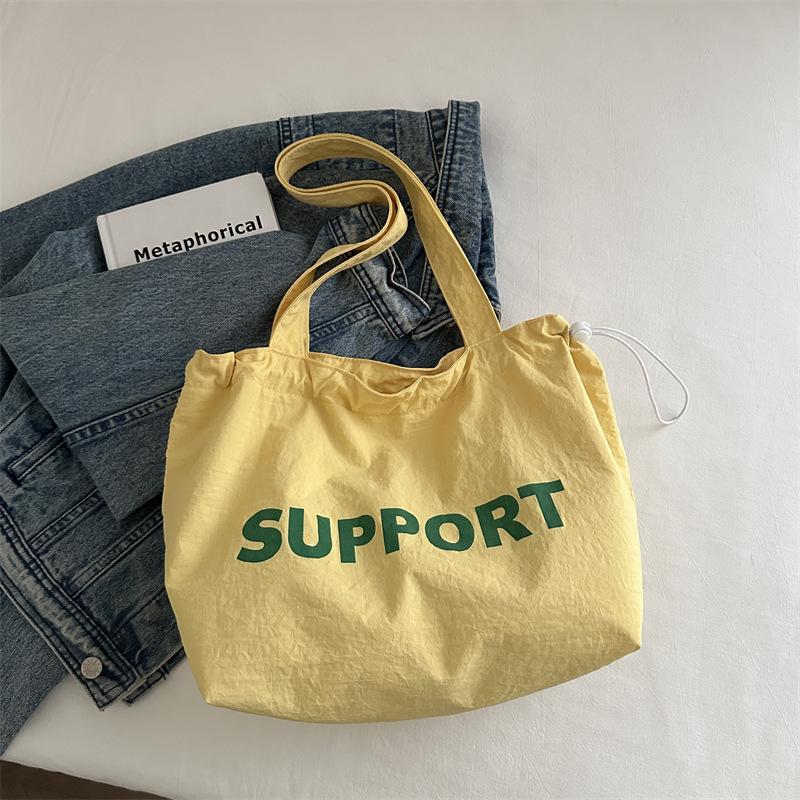 

Korean version of alphabet canvas bag women s 2025 autumn new relaxation large-capacity college student class bag nylon bag жёлтый