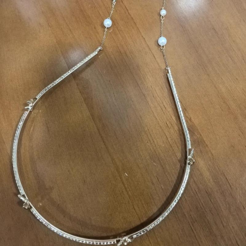 Ein Stirnband mit Metall-Schmetterlingsquaste, verziert mit künstlichen Perlen - ein rutschfestes Stirnband für langes Haar, ein stilvolles Accessoire für Frauen.