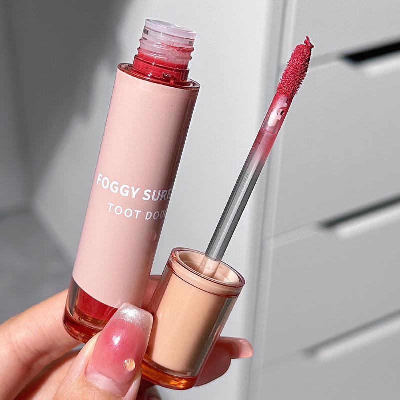 Toot Dodo Lippen-Mud: Leichter Rauchrosa Nude Lippenstift mit milchig-cremiger Textur für einen sanften, hautaufhellenden Stil.