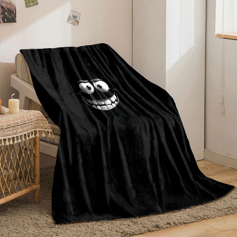 A glowing, cartoonish face with wide eyes and a big toothy grin on black. for all seasons blanket lunch break throw gift