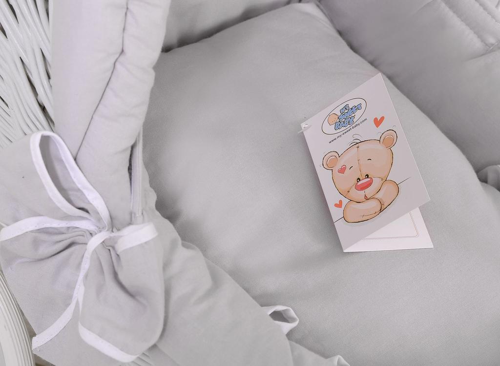 Witte rieten poppenwagen met grijze beddengoed en zachte voering