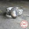 Vintage-style 925 sterling silver ring with oval moonstone and floral motif design, suitable for engagement