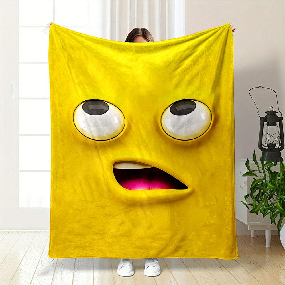 Bright yellow cartoon face with large eyes and an open mouth showing pink. for all seasons blanket lunch break throw gift