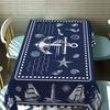 Una tovaglia a tema nautico in stile costiero blu navy, con motivi di ancore, fari e bussole, yzb