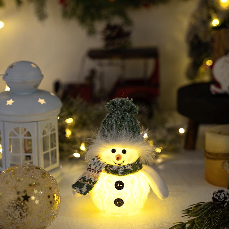 Weihnachts-Schneemann-Dekoration mit grüner Strickmütze und Lichtern