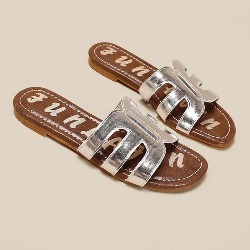 

Простые темпераментные однословные шлепанцы на плоской подошве женские полые с узором под камень коровья кожа с бронзовым тиснением букв 38 серебряный