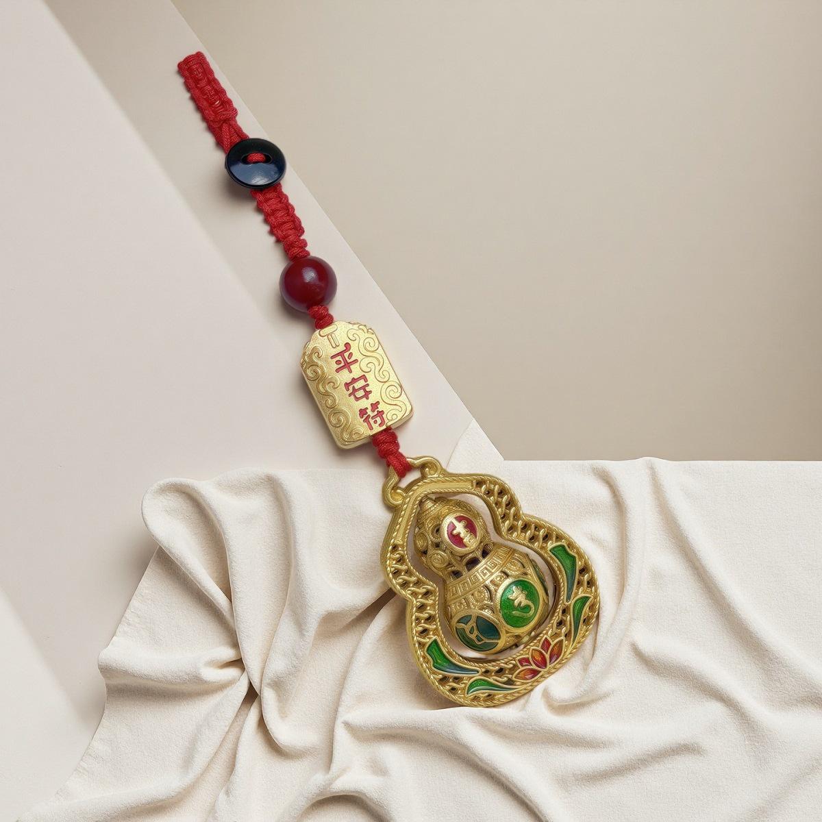 

Китайский брелок из песочного золота с молитвенным барабаном мира и подвеской в виде полой тыквы-горлянки