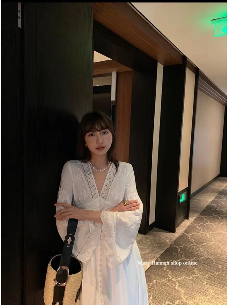 Robe blanche à manches longues et broderie ajourée pour les vacances à l'île ou à la plage