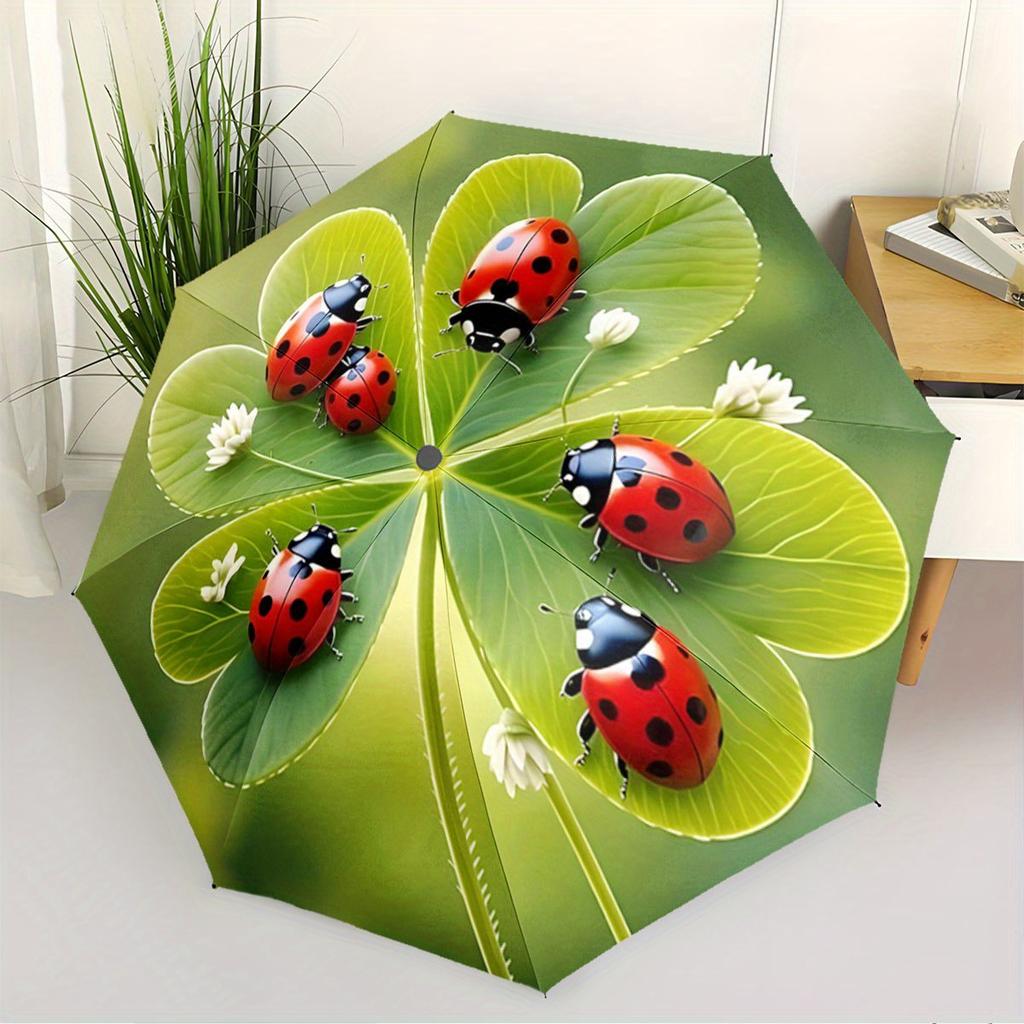 A Compact Folding Umbrella Featuring Ladybugs On a Backdrop of Green Leaves, Perfect for Gifting On Any Occasion.