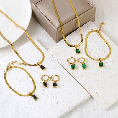 Sada šperků z nerezové oceli se zelenými diamanty: Náhrdelník, náramek a náušnice v trendy stylu a čtvercovém designu.
