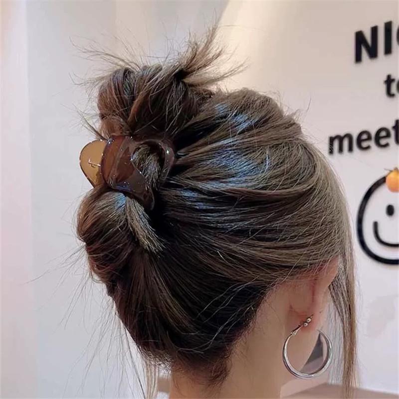 Fermagli per Capelli da Donna dall'Aspetto Sofisticato, con uno Chignon Basso con Capelli Spaziati sul Retro, e un Accessorio per Capelli a Forma di Squalo.