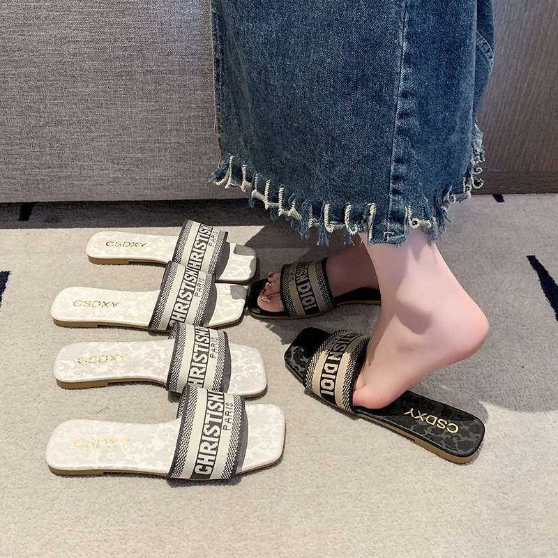 Pantofle haftowane literami damskie do noszenia na zewnątrz 2025 lato nowa moda płaska podeszwa do noszenia na zewnątrz plażowe jednosłowne sandały ins tide