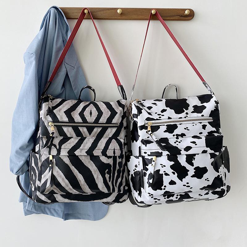Neuer PU Retro Rucksack mit großer Kapazität für Reisen, Kuhmuster, schlichter britischer Stil, schräg über die Schulter tragbar, für Damen