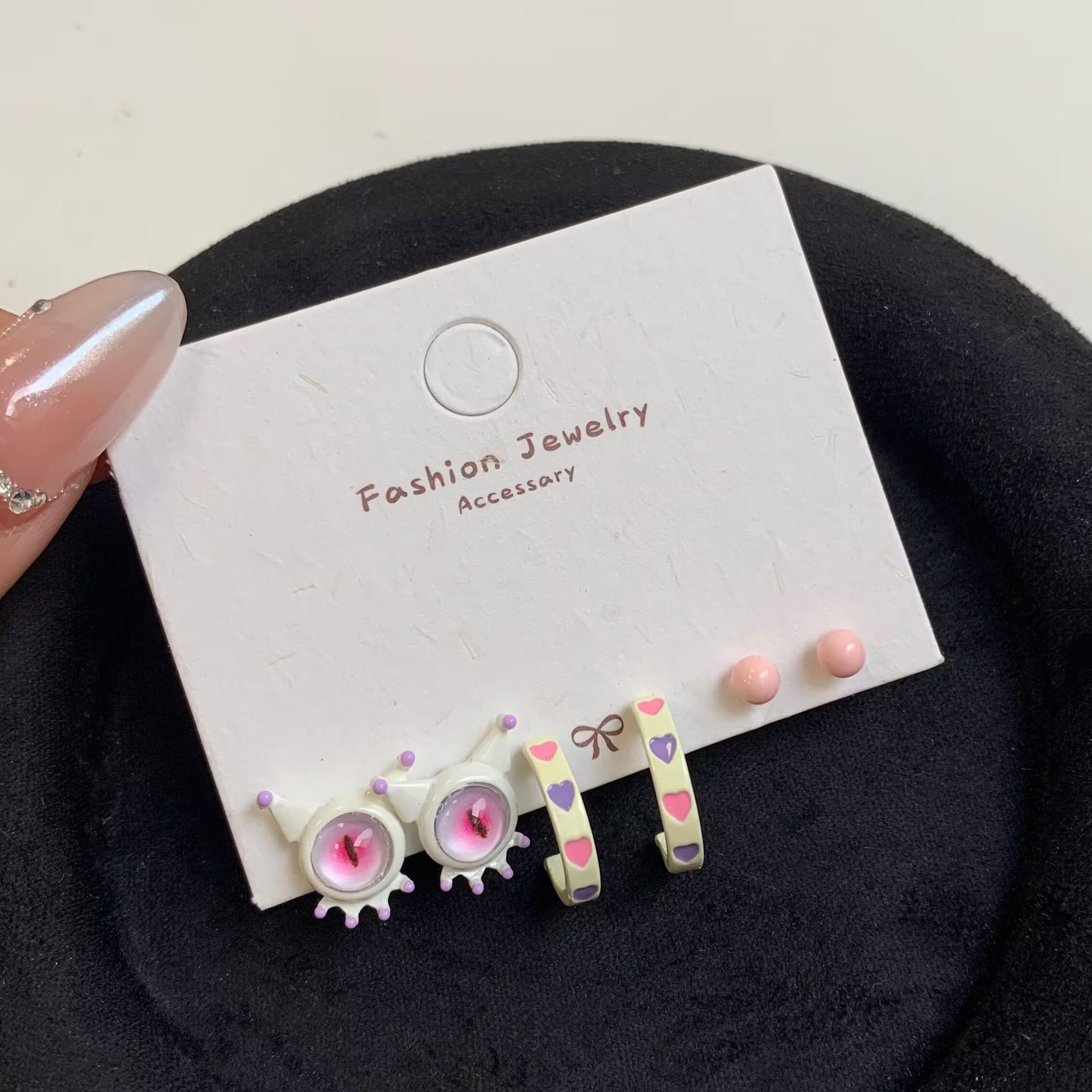 

Очаровательный комплект из сережек в виде маленького монстра и серебряных игл с персиковым сердечком